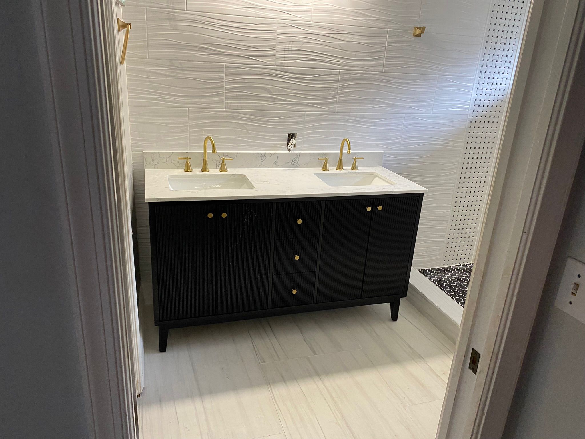 Baño remodelado con doble tocador y grifería dorada - Newport, RI
