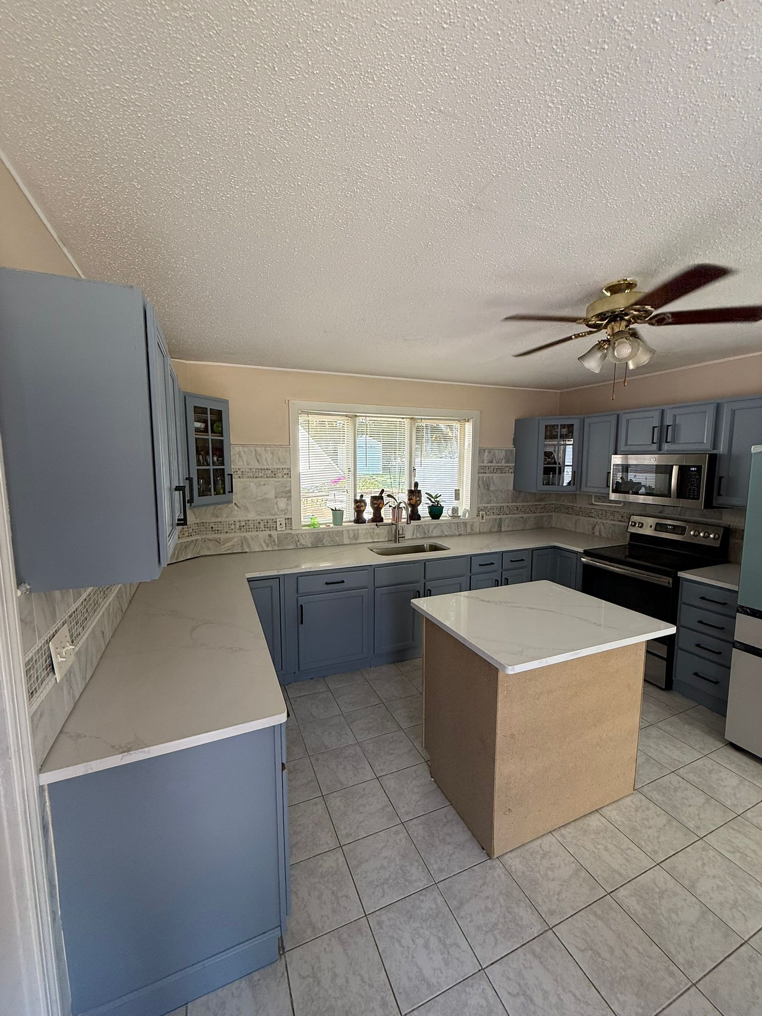 Renovación de cocina con gabinetes azul grisáceo y backsplash de mármol - Westerly, RI